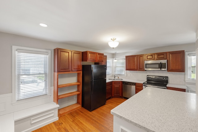 359 Stratford Dr, Lexington, KY 40503 - kitchen with black appliances, a sink, light countertops, light wood finished floors, and brown cabinetry