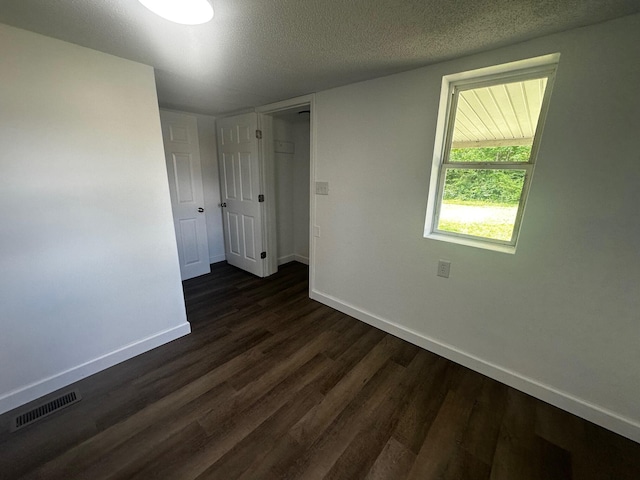 1901 Holly Grove Rd, Corbin, KY 40701 - unfurnished room featuring baseboards, dark wood-style flooring, and a textured ceiling
