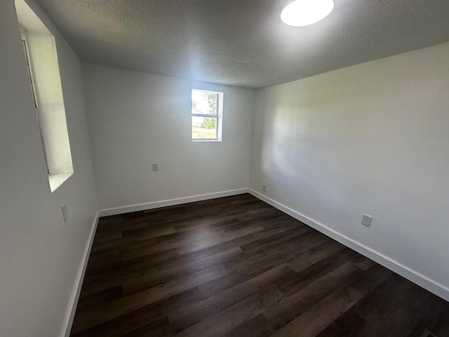 1901 Holly Grove Rd, Corbin, KY 40701 - spare room with dark wood-type flooring, a textured ceiling, and baseboards