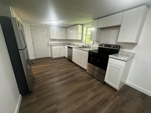 1901 Holly Grove Rd, Corbin, KY 40701 - kitchen with appliances with stainless steel finishes, baseboards, a sink, white cabinetry, and dark wood finished floors