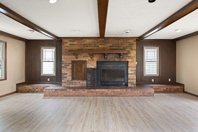 99 Wilson Ln, London, KY 40741 - unfurnished living room featuring wood finished floors, beamed ceiling, baseboards, plenty of natural light, and wooden walls