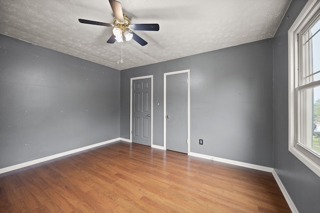 99 Wilson Ln, London, KY 40741 - unfurnished bedroom featuring a textured ceiling, wood finished floors, baseboards, and a ceiling fan