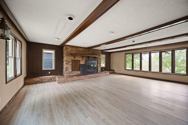 99 Wilson Ln, London, KY 40741 - unfurnished living room featuring beam ceiling, wood finished floors, a textured ceiling, baseboards, and a fireplace