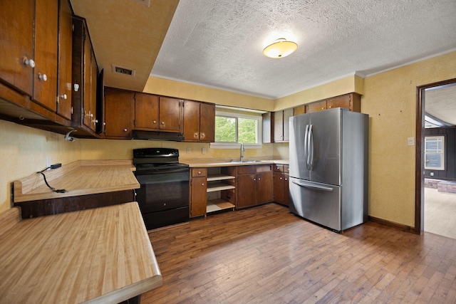 99 Wilson Ln, London, KY 40741 - kitchen with freestanding refrigerator, black range with electric stovetop, under cabinet range hood, light countertops, and a textured ceiling