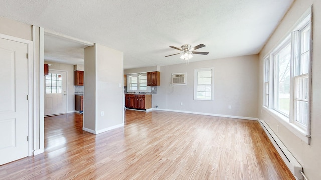 220 Johnson Ln, Berea, KY 40403 - unfurnished living room featuring baseboard heating, light wood finished floors, ceiling fan, plenty of natural light, and a textured ceiling