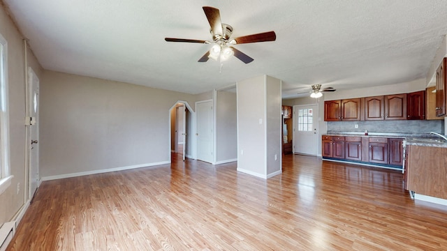 220 Johnson Ln, Berea, KY 40403 - unfurnished living room with light wood-style floors, ceiling fan, a sink, baseboards, and a textured ceiling