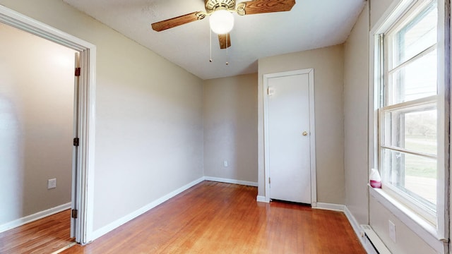 220 Johnson Ln, Berea, KY 40403 - unfurnished bedroom featuring multiple windows, light wood-type flooring, baseboards, and a baseboard radiator