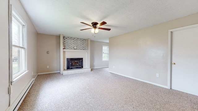 220 Johnson Ln, Berea, KY 40403 - unfurnished living room with baseboard heating, ceiling fan, a large fireplace, carpet floors, and baseboards