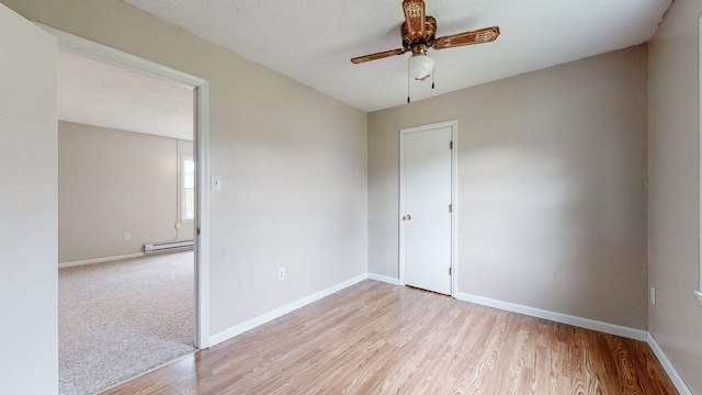 220 Johnson Ln, Berea, KY 40403 - spare room featuring a baseboard radiator, a ceiling fan, light wood finished floors, and baseboards
