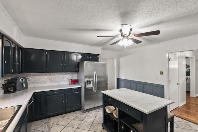126 Frankie Dr, Richmond, KY 40475 - kitchen with stainless steel refrigerator with ice dispenser, dark cabinetry, a ceiling fan, light tile patterned floors, and a sink