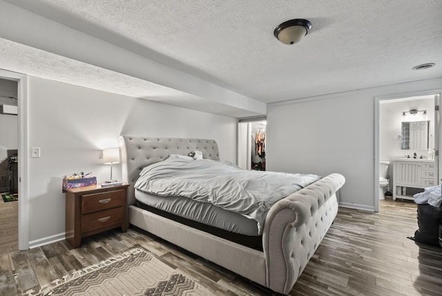 126 Frankie Dr, Richmond, KY 40475 - bedroom featuring wood finished floors, baseboards, a textured ceiling, connected bathroom, and a walk in closet