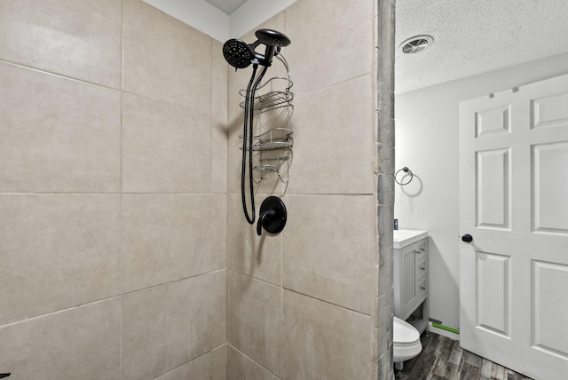 126 Frankie Dr, Richmond, KY 40475 - full bath featuring a tile shower, wood finished floors, vanity, toilet, and a textured ceiling