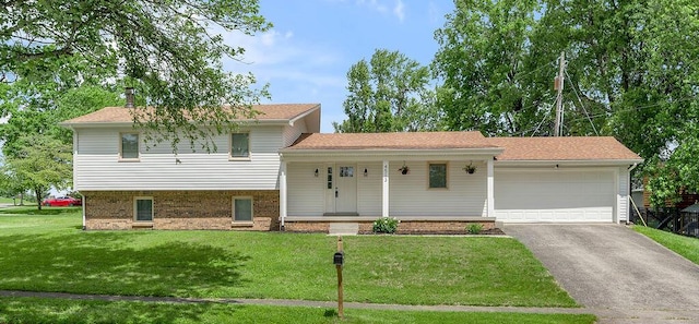 4513 Graves Dr, Lexington, KY 40515 - split level home with covered porch, asphalt driveway, a front lawn, an attached garage, and brick siding