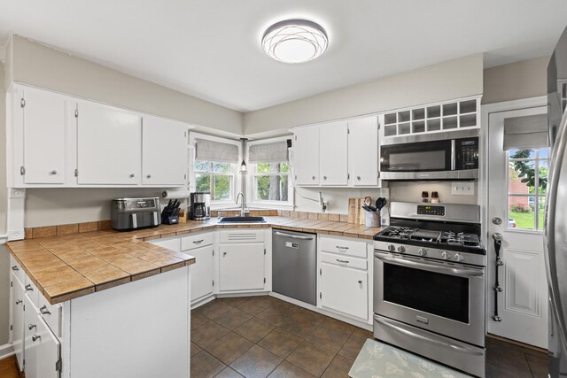 298 Hill N Dale Rd, Lexington, KY 40503 - kitchen featuring appliances with stainless steel finishes, a sink, white cabinets, and a peninsula
