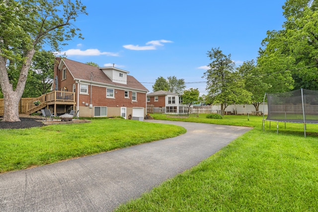 298 Hill N Dale Rd, Lexington, KY 40503 - view of yard with a trampoline, driveway, a garage, stairs, and a deck
