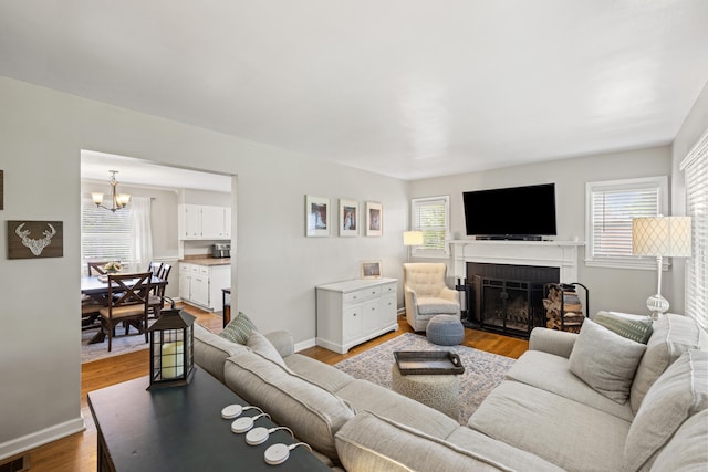 298 Hill N Dale Rd, Lexington, KY 40503 - living area featuring a fireplace, a chandelier, wood finished floors, and baseboards