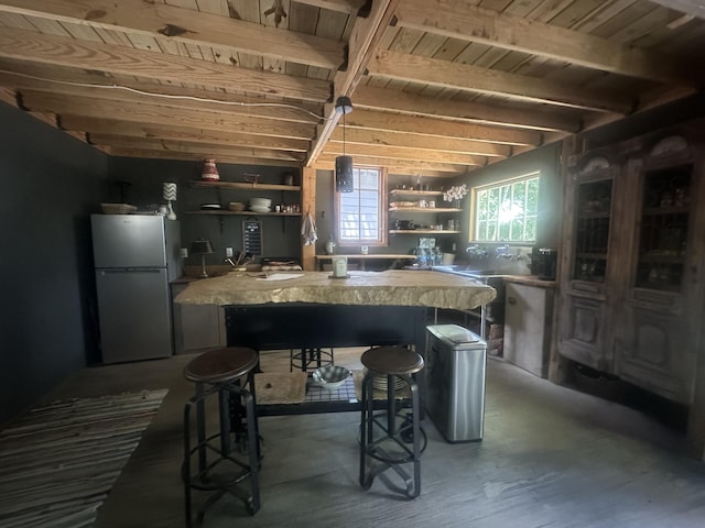 853 Rock Springs Rd, Celina, TN 38551 - kitchen featuring freestanding refrigerator, open shelves, wood ceiling with exposed beams, a kitchen breakfast bar, and wood finished floors