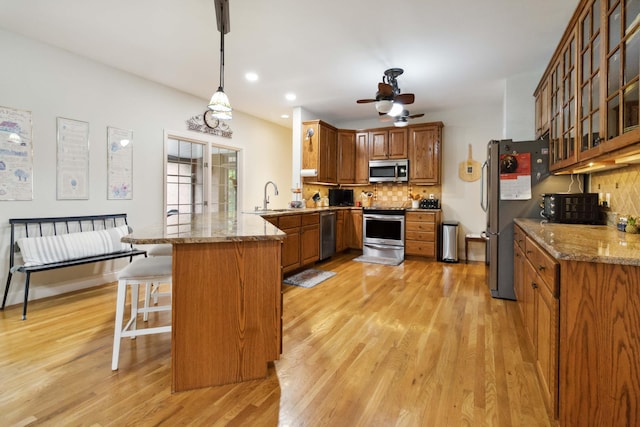 512 Water Cliff Dr, Somerset, KY 42503 - kitchen with a peninsula, stainless steel appliances, light wood-style floors, brown cabinets, and a sink