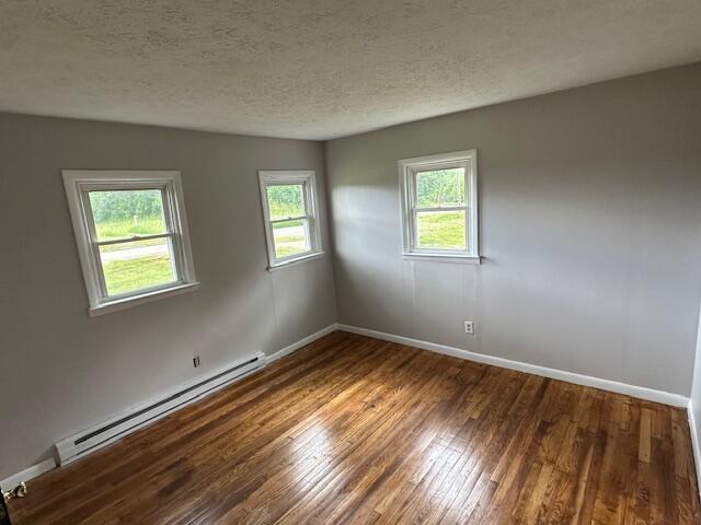 10650 Georgetown Rd, Owenton, KY 40359 - unfurnished room with a baseboard radiator, wood finished floors, and a textured ceiling
