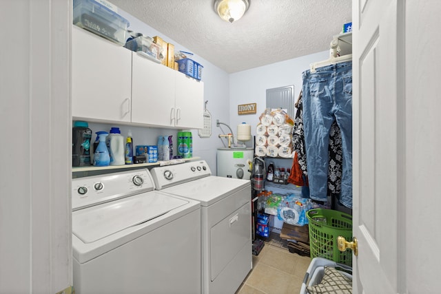 117 Autumn Dr, Russell Springs, KY 42642 - laundry area featuring washing machine and dryer, a textured ceiling, water heater, cabinet space, and light tile patterned floors