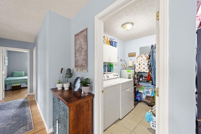 117 Autumn Dr, Russell Springs, KY 42642 - laundry area featuring a textured ceiling, washer and dryer, light wood-style floors, gas water heater, and cabinet space