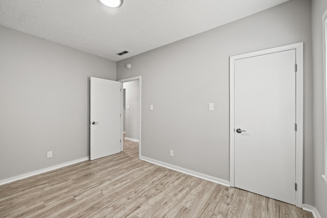 110 Hazel Ave, Lexington, KY 40502 - unfurnished bedroom with light wood-type flooring, a textured ceiling, and baseboards
