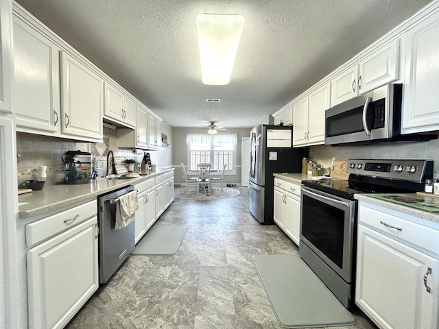 317 Hidden Loop Dr, Somerset, KY 42503 - kitchen featuring appliances with stainless steel finishes, a sink, white cabinetry, ceiling fan, and a textured ceiling