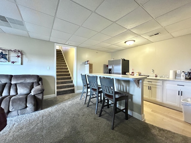 317 Hidden Loop Dr, Somerset, KY 42503 - kitchen featuring stainless steel fridge with ice dispenser, light colored carpet, white cabinets, a breakfast bar area, and a paneled ceiling
