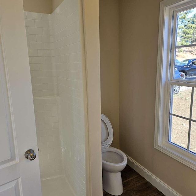 135 Watkins Branch Rd, East Bernstadt, KY 40729 - bathroom with tiled shower, baseboards, toilet, and wood finished floors