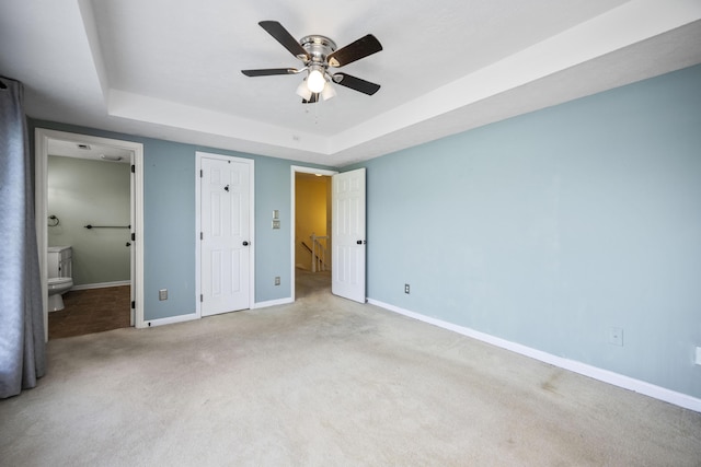 113 Medinah Ct, Frankfort, KY 40601 - unfurnished bedroom with a raised ceiling, baseboards, carpet floors, connected bathroom, and ceiling fan
