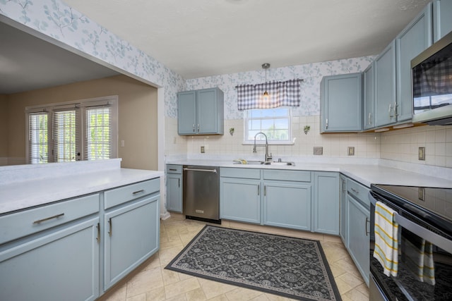 113 Medinah Ct, Frankfort, KY 40601 - kitchen featuring stainless steel appliances, a sink, wallpapered walls, plenty of natural light, and light countertops