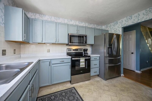 113 Medinah Ct, Frankfort, KY 40601 - kitchen with appliances with stainless steel finishes, wallpapered walls, light countertops, tasteful backsplash, and a sink