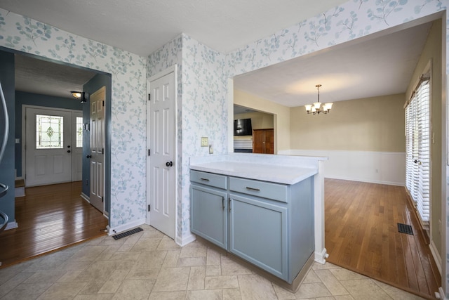 113 Medinah Ct, Frankfort, KY 40601 - kitchen with wallpapered walls, a chandelier, baseboards, light countertops, and a peninsula