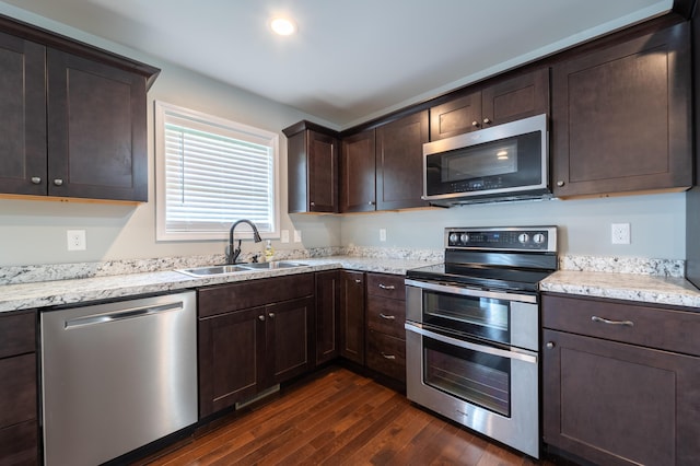 2296 Boonesborough Rd, Richmond, KY 40475 - kitchen featuring appliances with stainless steel finishes, a sink, dark wood-style floors, dark brown cabinetry, and light stone countertops