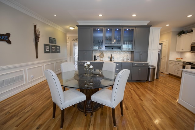 360 Persimmon Way, Harrodsburg, KY 40330 - dining area with crown molding, light wood-style flooring, recessed lighting, wet bar, and a wainscoted wall