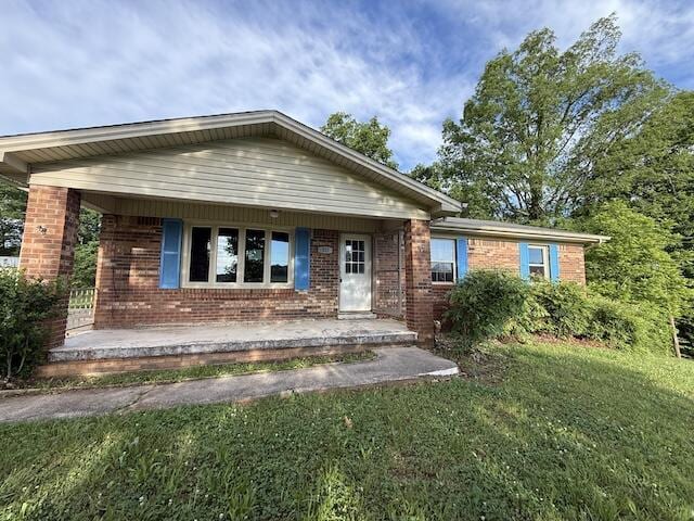 315 Della Winchester Rd, Nancy, KY 42544 - view of front facade featuring covered porch, brick siding, and a front yard