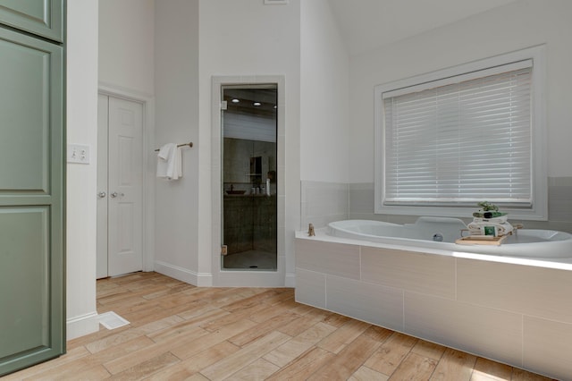 1304 Wakehurst Ct, Lexington, KY 40509 - full bath featuring a bath, a stall shower, lofted ceiling, and wood finished floors