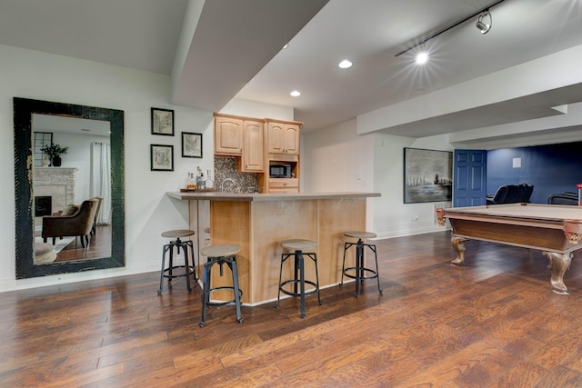 1304 Wakehurst Ct, Lexington, KY 40509 - kitchen with light brown cabinets, black microwave, a breakfast bar area, baseboards, and dark wood finished floors