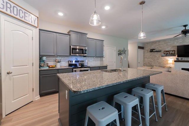 133 Kirkstall Way, Georgetown, KY 40324 - kitchen with appliances with stainless steel finishes, a sink, open floor plan, gray cabinets, and light wood finished floors