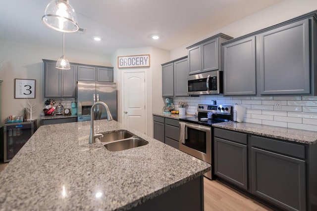 133 Kirkstall Way, Georgetown, KY 40324 - kitchen featuring appliances with stainless steel finishes, a sink, light stone countertops, backsplash, and light wood-style floors