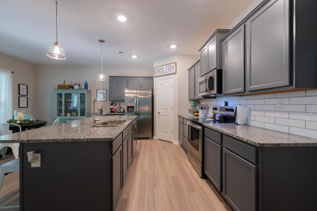 133 Kirkstall Way, Georgetown, KY 40324 - kitchen featuring stainless steel appliances, a sink, light wood-style flooring, backsplash, and stone countertops