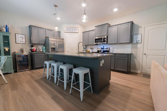 133 Kirkstall Way, Georgetown, KY 40324 - kitchen featuring appliances with stainless steel finishes, gray cabinets, a kitchen breakfast bar, light wood-type flooring, and recessed lighting