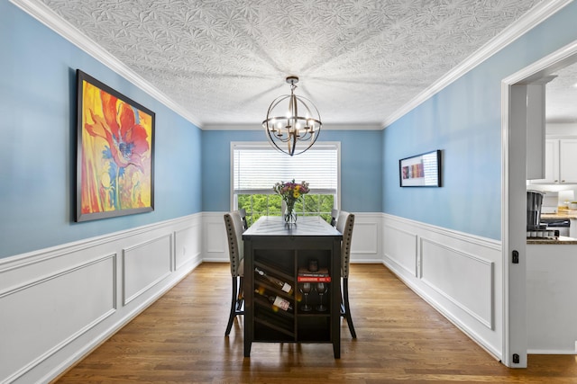 481 Alderbrook Way, Lexington, KY 40515 - dining area with a chandelier, wainscoting, wood finished floors, a decorative wall, and crown molding