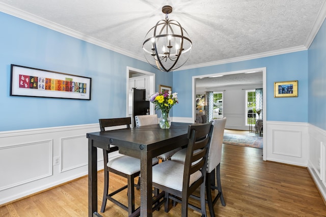 481 Alderbrook Way, Lexington, KY 40515 - dining space with a chandelier, wood finished floors, wainscoting, a decorative wall, and crown molding