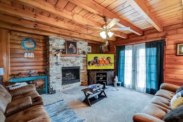 116 Hickory Lick Rd, Richmond, KY 40475 - living room featuring carpet, wood ceiling with exposed beams, ceiling fan, a stone fireplace, and wooden walls