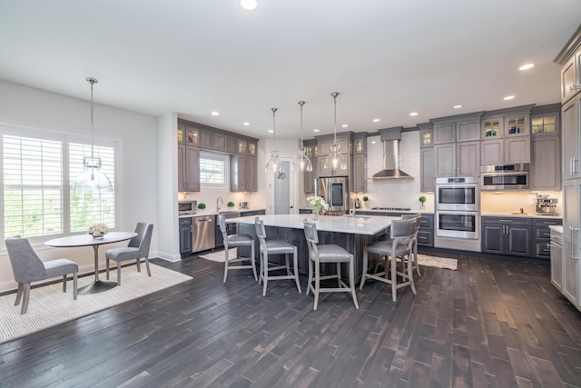 2605 Lucca Pl, Lexington, KY 40509 - kitchen featuring wall chimney range hood, dark wood-style floors, appliances with stainless steel finishes, gray cabinetry, and recessed lighting