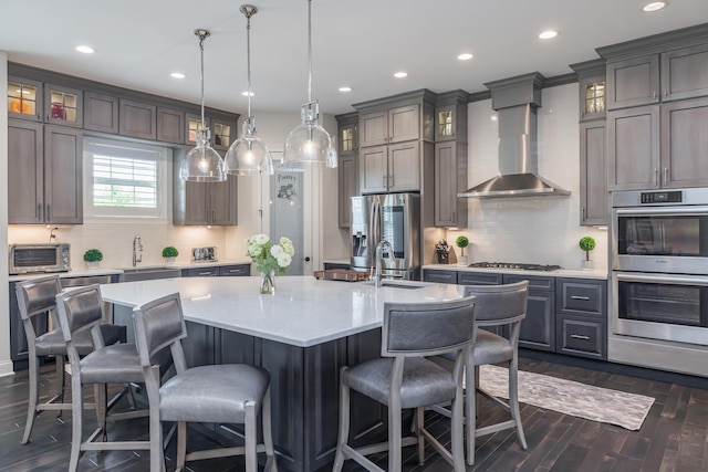 2605 Lucca Pl, Lexington, KY 40509 - kitchen with stainless steel appliances, wall chimney exhaust hood, a sink, a kitchen island with sink, and recessed lighting