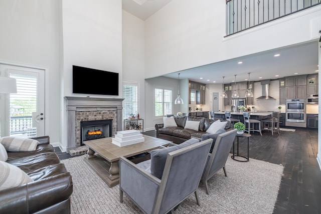 2605 Lucca Pl, Lexington, KY 40509 - living area featuring dark wood-style floors, a tile fireplace, a towering ceiling, and baseboards
