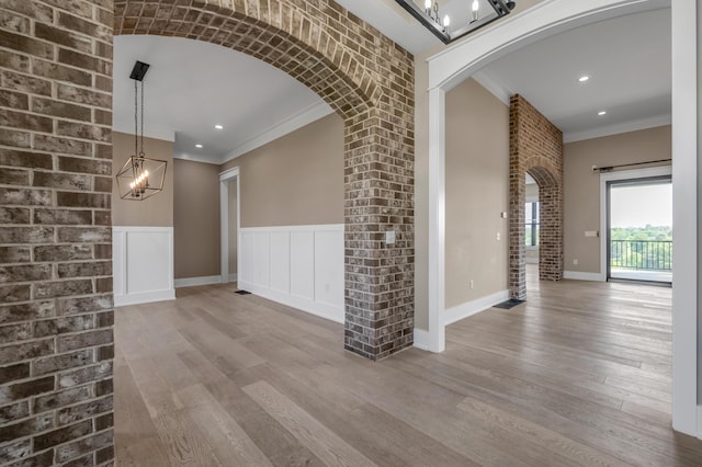 1408 Champion Way, Richmond, KY 40475 - spare room featuring a chandelier, crown molding, arched walkways, wood finished floors, and baseboards