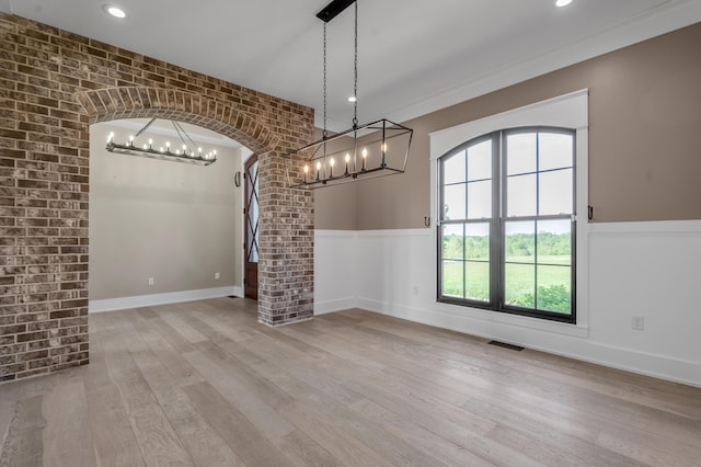 1408 Champion Way, Richmond, KY 40475 - unfurnished dining area with a chandelier, arched walkways, wainscoting, wood-type flooring, and brick wall